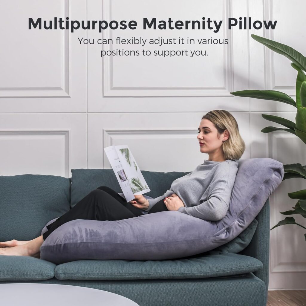 Momcozy U-shaped pregnancy pillow with a cooling, removable cover on a bed. The pillow features a soft, curved design that supports the head, belly, and legs for comfortable sleep during pregnancy.