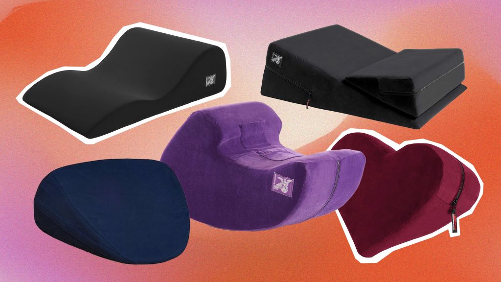 A variety of ergonomic foam wedge and bolster pillows designed for intimacy, arranged on a neutral-colored bed.